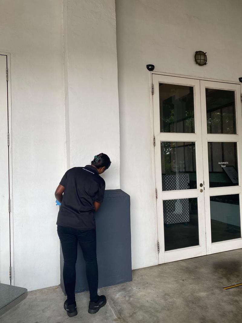CleanLee cleaner wiping down fixtures beside a building entrance